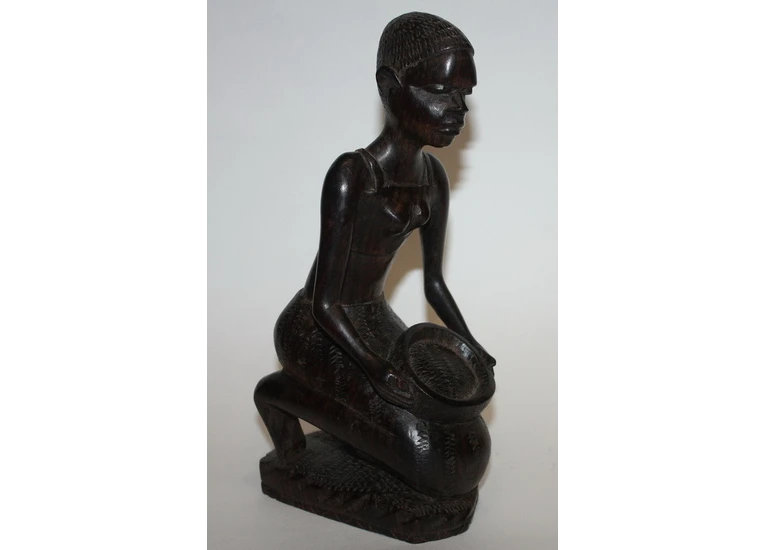 Девушка сидит с корзиной - черное дерево, Африка.