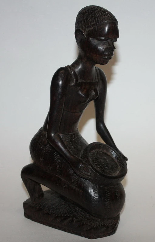 Дівчина сидить із кошиком — чорне дерево, Африка.